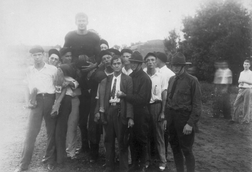 Early photo of a football player carried on shoulders of group of men