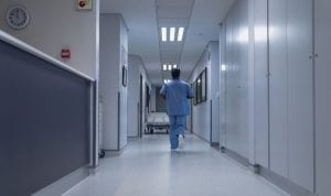 hospital hallway with caregiver walking away