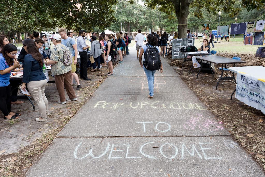 Students walking campus with chalk on the sidewalk.