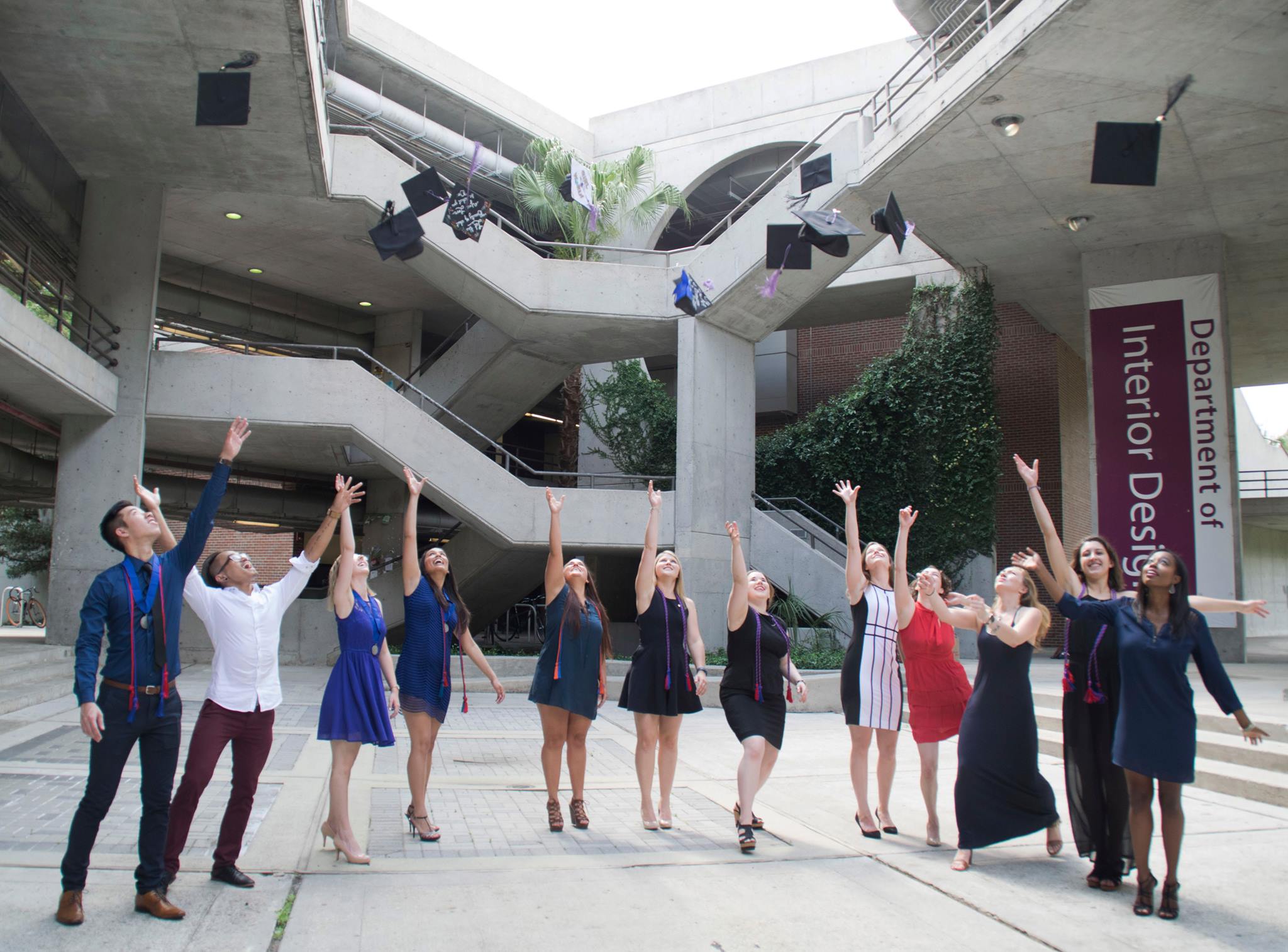 grads throwing caps in architecture building atrium