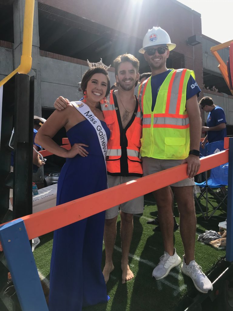 Julianna (Chappell) Nickel, Joey Vicari and Alan Bailey celebrating on the Rinker Float at the 2021 Homecoming Parade.